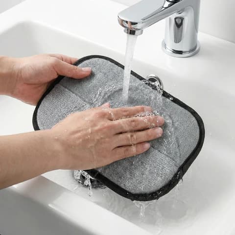ShedEase reusable pad being rinsed clean under running water